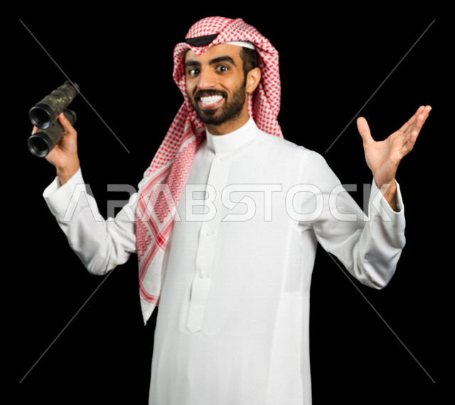 رجل عربي خليجي سعودي يرتدي الزي السعودي التقليدي ، يحمل بيده المنظار ثنائي العينين ( التلسكوب )، إيماءات وجه ويدين مختلفة ، الناظور، الاستكشاف والمغامرة ، خلفية سوداء، رؤية مستقبلية ، أهداف وطموحات ، التخطيط المستقبلي