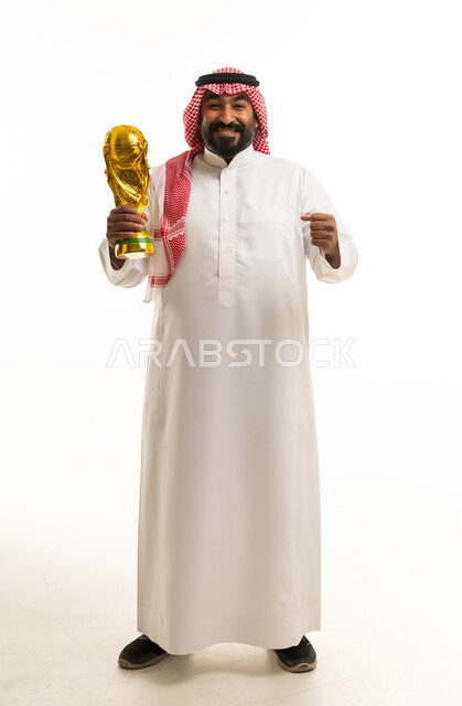 رجل سعودي يحمل كأساً ذهبياً للاحتفال بالفوز