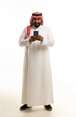 Saudi Man in Traditional Thobe Using Smartphone