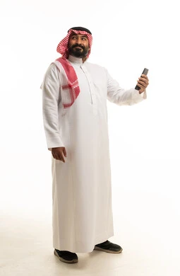 Saudi Man in Traditional Thobe Holding Smartphone Studio