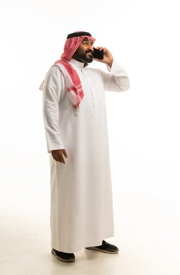 Saudi Man in Traditional Dress Talking on Smartphone