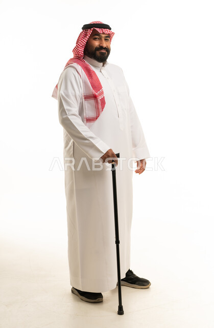 رجل سعودي بالزي التقليدي مع عصا مشي