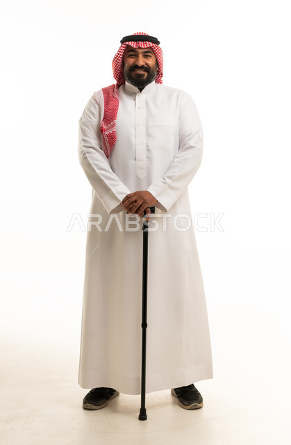 رجل سعودي بالزي التقليدي مع عصا مشي