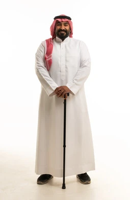 رجل سعودي بالزي التقليدي مع عصا مشي