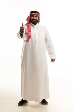 رجل سعودي بالثوب التقليدي يشير بعلامة الإعجاب