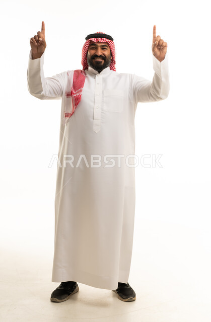رجل سعودي بالثوب التقليدي يشير للأعلى بخلفية بيضاء