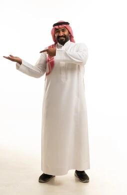رجل سعودي بالثوب التقليدي يقدم عرضاً على خلفية بيضاء