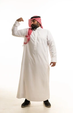 Saudi Man in Traditional Thobe Flexing Bicep in Studio