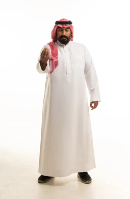 رجل سعودي بالزي التقليدي يقوم بإيماءة باليد