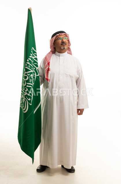 رجل سعودي يحمل العلم الوطني في الاستوديو