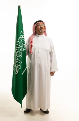 رجل سعودي يحمل العلم الوطني في الاستوديو