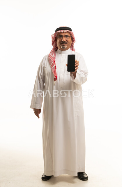 رجل سعودي يحمل هاتف ذكي على خلفية بيضاء