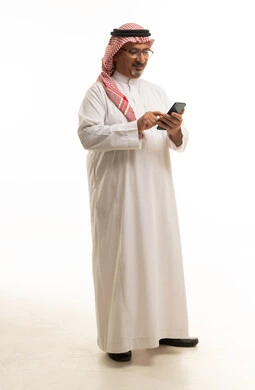 Saudi Man in Traditional Thobe Using Smartphone on White