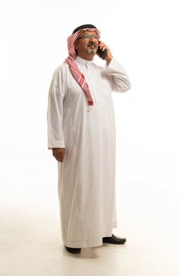 رجل سعودي يتحدث بالهاتف الذكي بخلفية بيضاء
