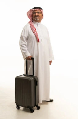 رجل سعودي يحمل حقيبة سفر على خلفية بيضاء