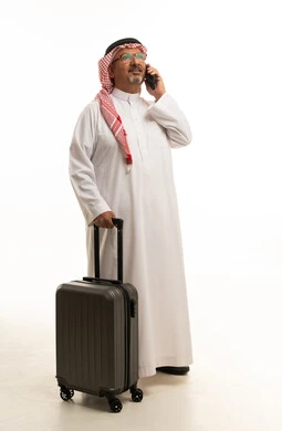 رجل سعودي مع حقيبة سفر يتحدث بالهاتف الذكي استوديو