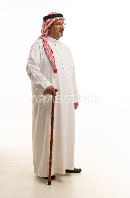 رجل سعودي بالزي التقليدي يمسك عصا المشي