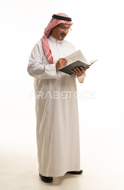 Saudi Man Reading Book in Traditional Attire