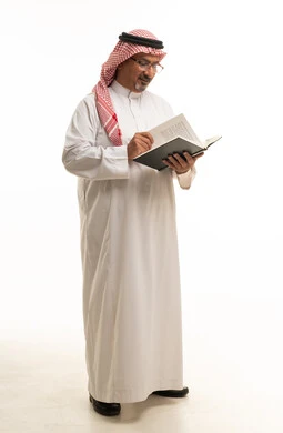 Saudi Man Reading Book in Traditional Attire