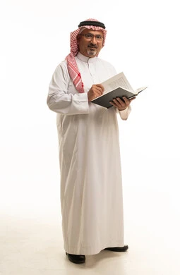 رجل سعودي يقرأ كتاباً على خلفية بيضاء