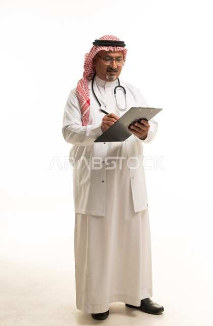 طبيب سعودي يكتب على لوحة ملاحظات بخلفية بيضاء