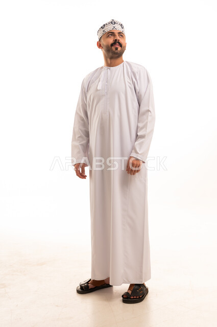 رجل عماني بالدشداشة والكمة التقليدية على خلفية بيضاء