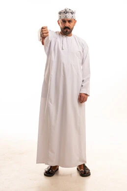 رجل عماني بالزي التقليدي يشير بعلامة عدم الإعجاب