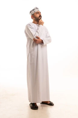 رجل عماني باللباس التقليدي في وضعية تفكير