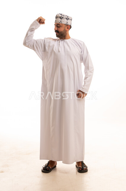 Omani Man in Traditional Dishdasha Flexing Muscles