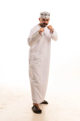 Omani Man in Traditional White Dishdasha Boxing Pose