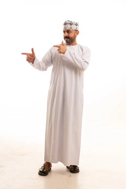 رجل عماني بالزي التقليدي يشير إلى الجانب