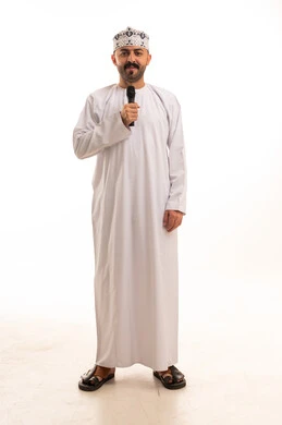 رجل عماني يمسك ميكروفون بالزي التقليدي