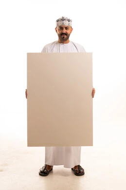 رجل عماني بالزي التقليدي يحمل لوحة بيضاء فارغة