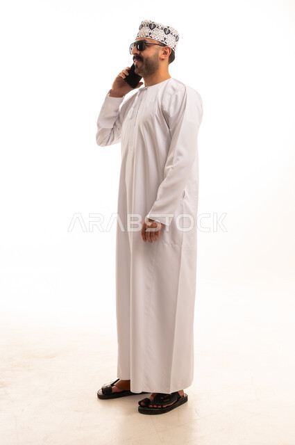 Omani Man in Traditional Dress on Smartphone