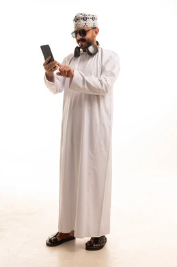 رجل عماني مع هاتف ذكي وخلفية استوديو بيضاء