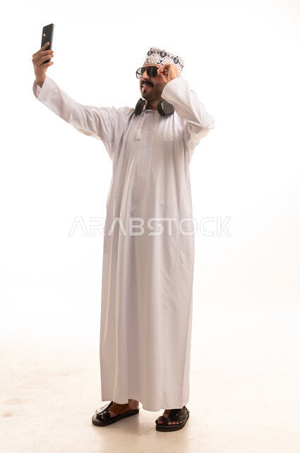 Omani Man in Traditional Dishdasha Taking Smartphone Selfie