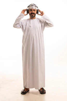 رجل عُماني بالدشداشة التقليدية يرتدي سماعات الرأس