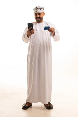 رجل عماني مع هاتف ذكي وبطاقة ائتمان خلفية بيضاء