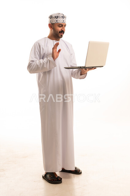 رجل عماني بالزي التقليدي يستخدم المحمول