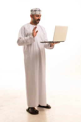 Omani Man in Traditional Dress Using Laptop