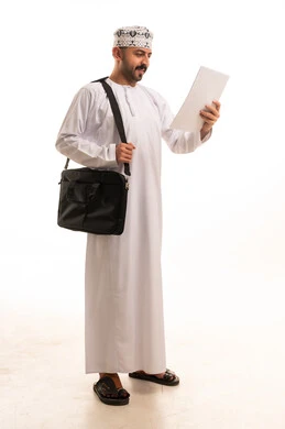 Omani Man in Traditional Dress Reading Document