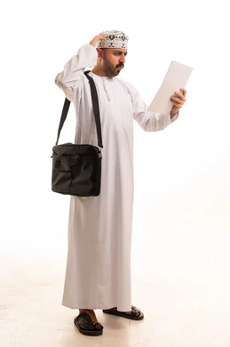 Omani Man in Traditional Dishdasha Reading Document