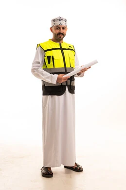 مهندس عُماني بزي السلامة يحمل مخططاً هندسياً