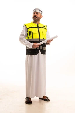 مهندس عماني بسترة السلامة يحمل مخططاً هندسياً