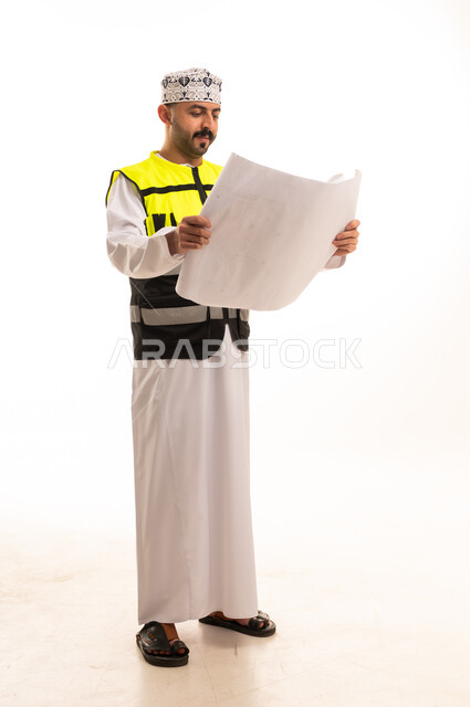 Omani Engineer Holding Blueprints in Safety Vest