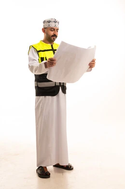 مهندس عماني يحمل مخططات معمارية مع سترة السلامة