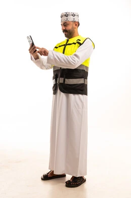 Omani Man in Safety Vest Using Smartphone on White