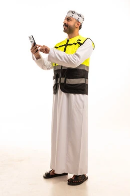 Omani Man in Safety Vest Using Smartphone on White Background