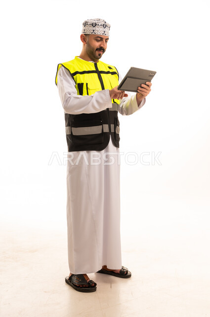 Omani Engineer in Safety Vest Using Digital Tablet