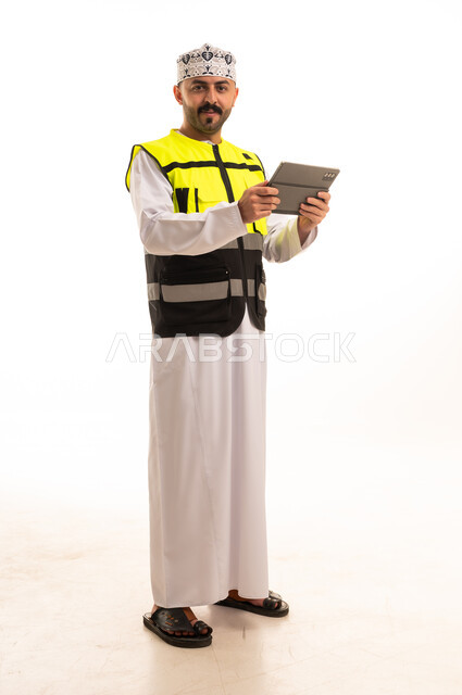 Omani Engineer in Safety Vest Holding Tablet